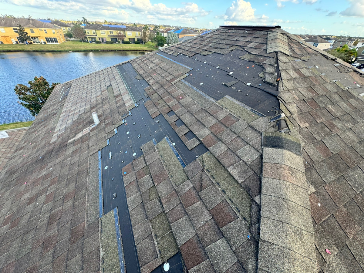 Shingle roof with missing shingles and exposed underlayment